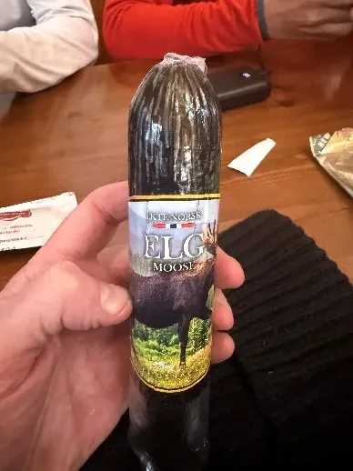 A small bottle of local drink held up at the refuge table